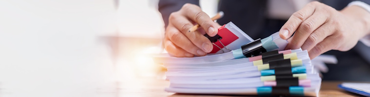 Banner with hand flicking through pile of report papers