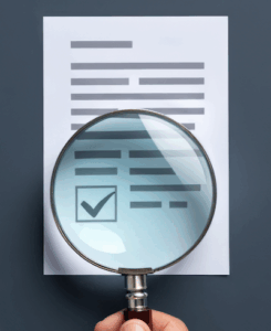 Hand holding a magnifying glass over a digital document