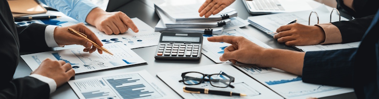 Team of office workers sitting around a table discussing compliance monitoring